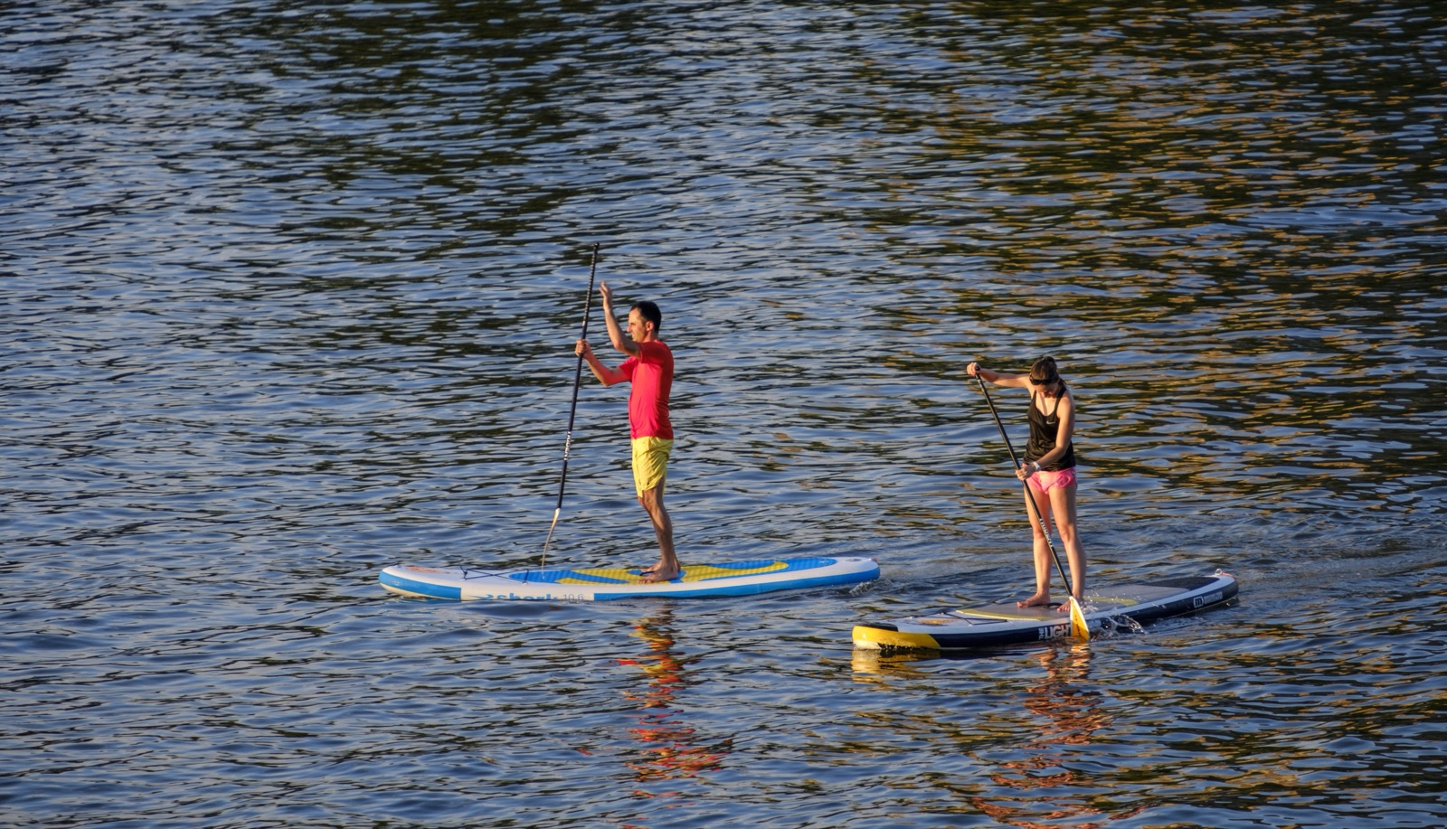 Deux paddlers sur le lac de Pont-de-Salars au coucher du soleil